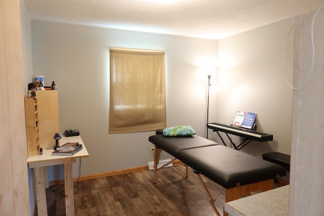 interior space featuring baseboards, a textured ceiling, and wood finished floors