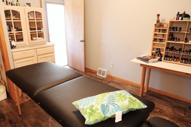 bedroom featuring baseboards, visible vents, and wood finished floors