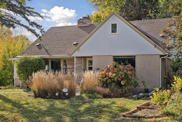 3522 Benjamin St NE, Minneapolis, MN 55418 - back of house with a yard, a chimney, roof with shingles, and stucco siding