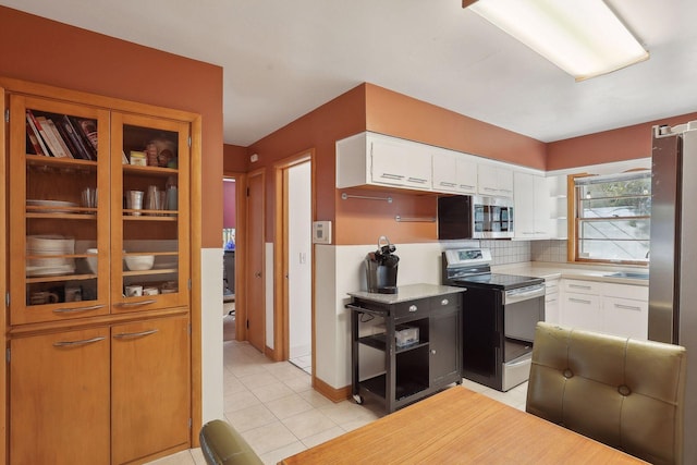 3522 Benjamin St NE, Minneapolis, MN 55418 - kitchen featuring stainless steel appliances, white cabinets, light countertops, light tile patterned floors, and backsplash