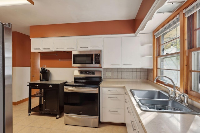 3522 Benjamin St NE, Minneapolis, MN 55418 - kitchen featuring appliances with stainless steel finishes, a sink, light countertops, white cabinetry, and open shelves
