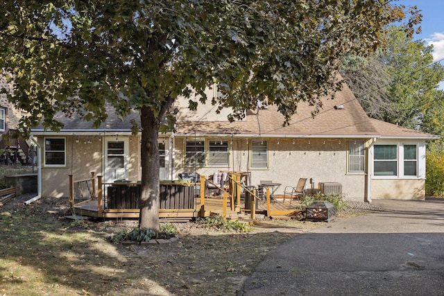 3522 Benjamin St NE, Minneapolis, MN 55418 - back of property featuring stucco siding, a deck, cooling unit, and a shingled roof