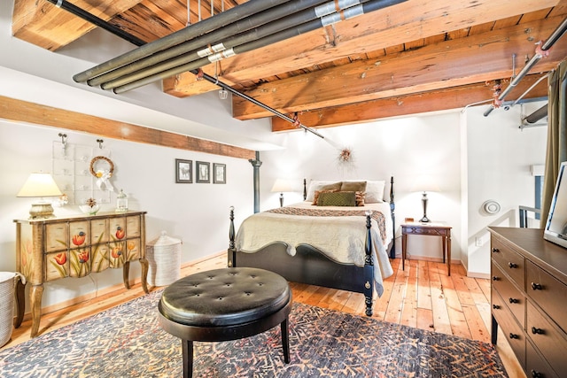 bedroom featuring beamed ceiling, light hardwood / wood-style floors, and wooden ceiling