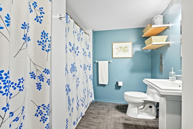 bathroom with a shower with shower curtain and toilet