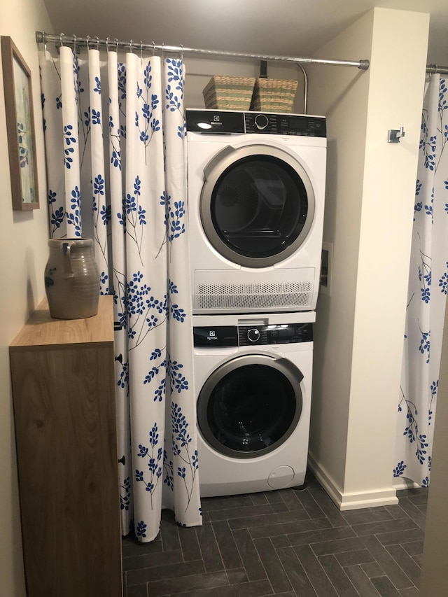 washroom featuring stacked washer and clothes dryer