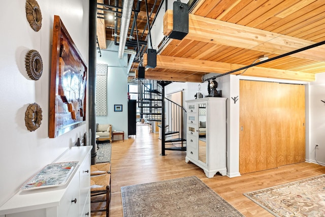 hall with light hardwood / wood-style flooring, beamed ceiling, and wood ceiling