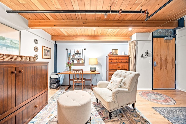 living area with beam ceiling, wood ceiling, and light hardwood / wood-style flooring