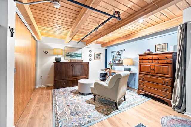 living area featuring beamed ceiling, light hardwood / wood-style flooring, and wooden ceiling