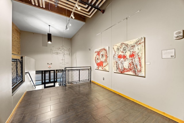 empty room featuring beam ceiling and a high ceiling