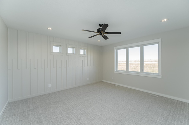 carpeted spare room with ceiling fan