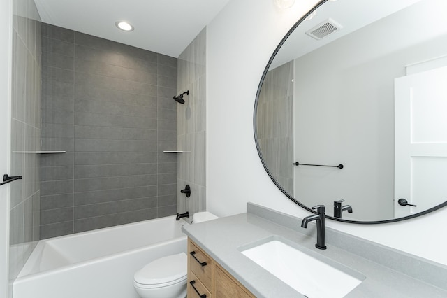 full bathroom with vanity, tiled shower / bath, and toilet