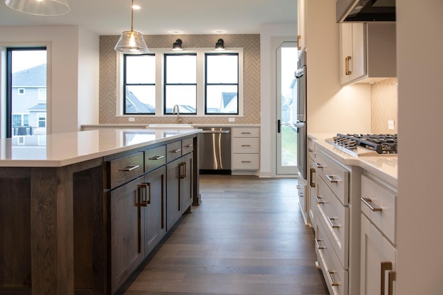 kitchen with decorative light fixtures, a wealth of natural light, stainless steel appliances, and white cabinetry