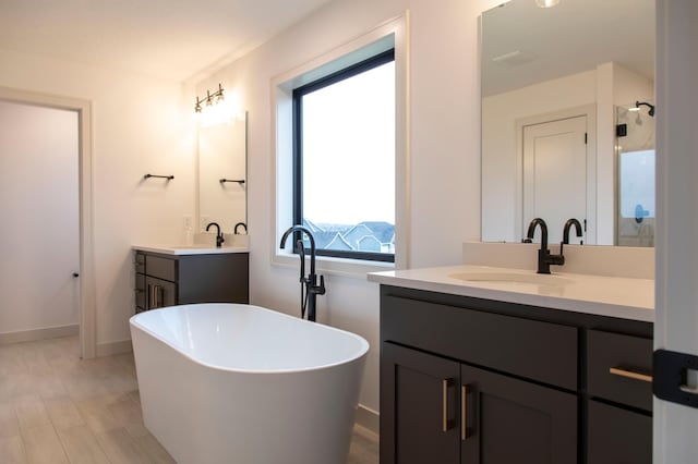 bathroom with independent shower and bath, wood-type flooring, and vanity