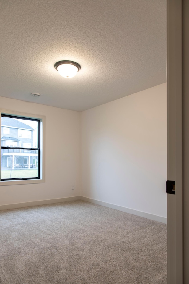 carpeted spare room featuring a textured ceiling