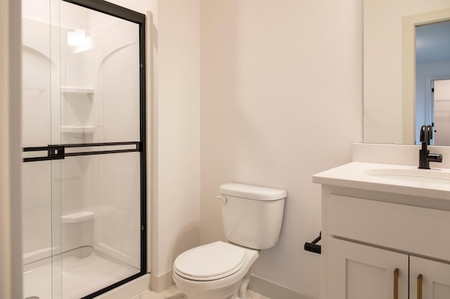 bathroom featuring an enclosed shower, vanity, and toilet