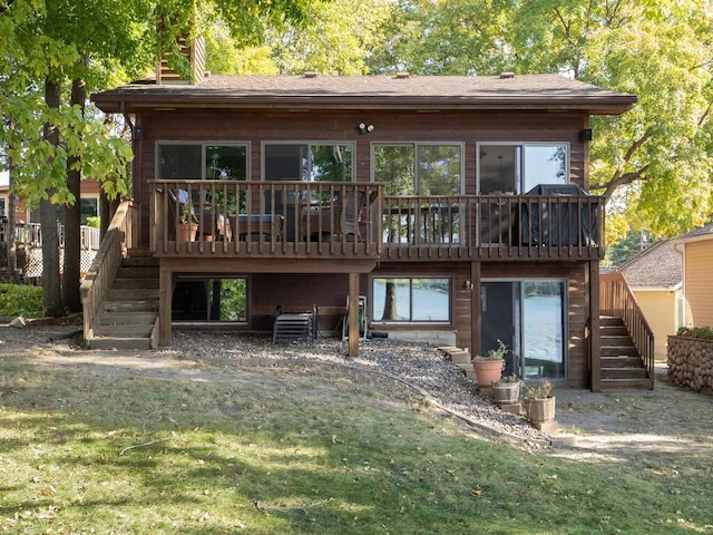 rear view of property with a yard, stairway, and a deck