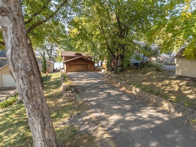 view of property hidden behind natural elements featuring a garage