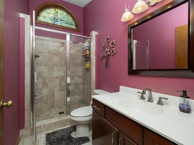 bathroom featuring vanity, tile patterned flooring, toilet, and a shower with shower door