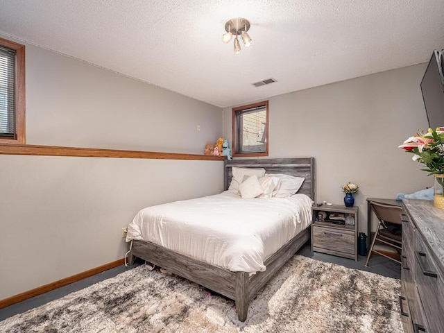 bedroom with baseboards, a textured ceiling, visible vents, and carpet