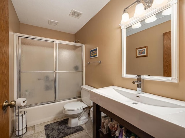 bathroom featuring visible vents, toilet, enclosed tub / shower combo, and vanity