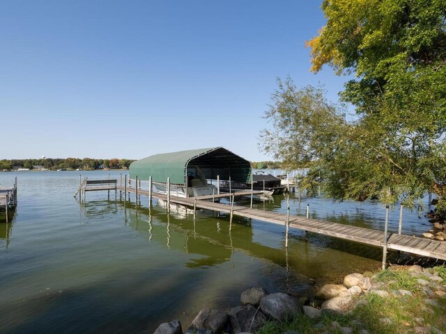 dock area with boat lift and a water view