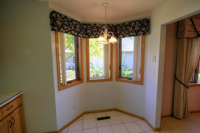 dining space with light tile patterned flooring and a chandelier