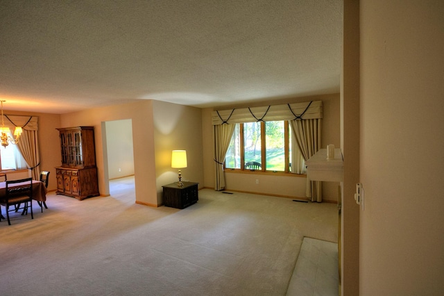 carpeted living room with a textured ceiling and an inviting chandelier