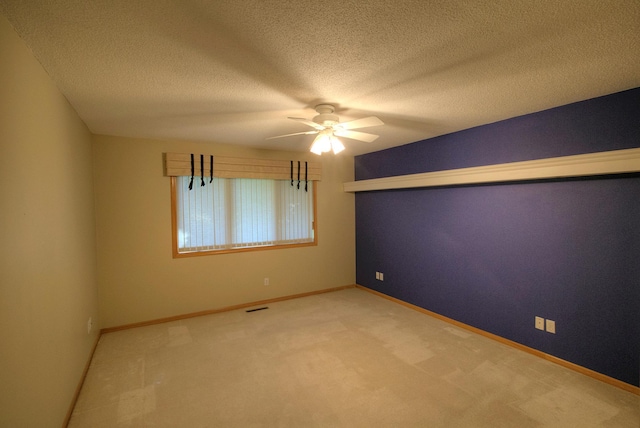 empty room featuring carpet flooring, ceiling fan, and a textured ceiling