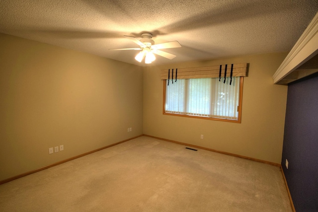 carpeted empty room with a textured ceiling and ceiling fan