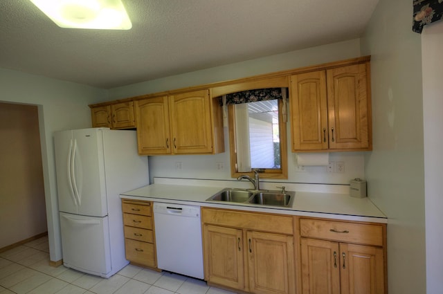 kitchen featuring light countertops, a sink, a textured ceiling, brown cabinetry, and white appliances