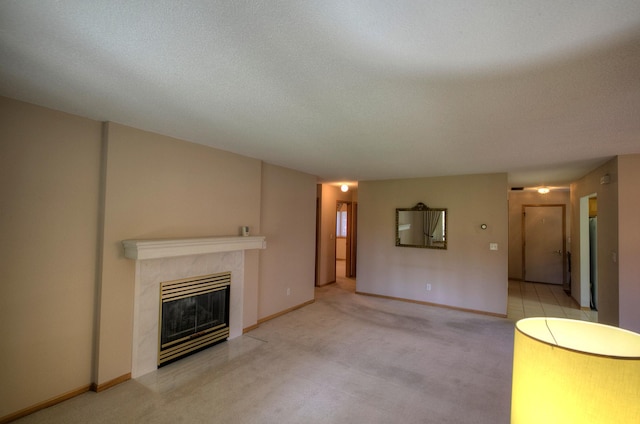 unfurnished living room featuring baseboards, a tiled fireplace, and carpet