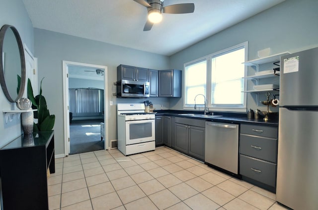 kitchen featuring ceiling fan, light tile patterned flooring, sink, gray cabinets, and stainless steel appliances