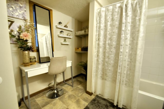 bathroom with a textured ceiling and shower / tub combo