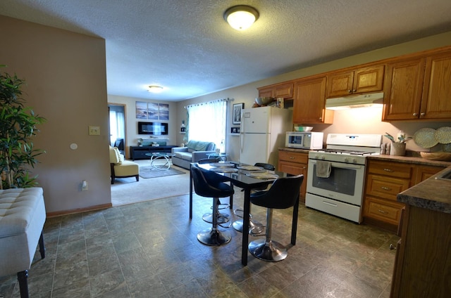 kitchen featuring a textured ceiling and white appliances