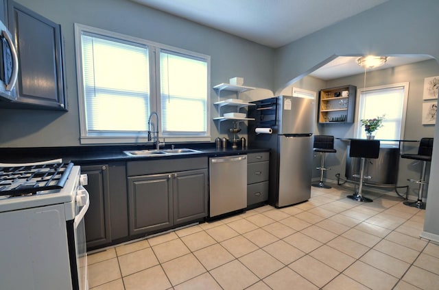 kitchen featuring sink, stainless steel appliances, a healthy amount of sunlight, and light tile patterned floors