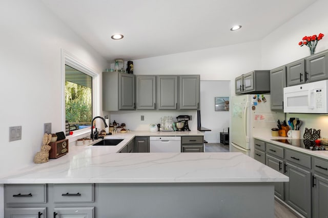 kitchen featuring light stone countertops, white appliances, gray cabinets, and sink