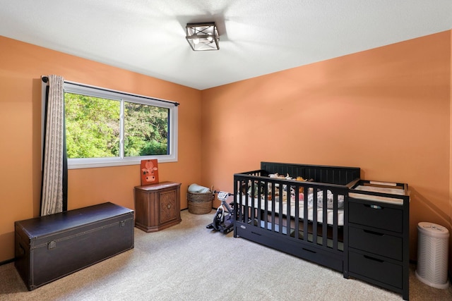 bedroom featuring a crib and carpet floors