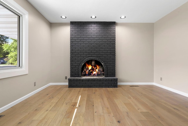 unfurnished living room featuring light wood-type flooring and a fireplace