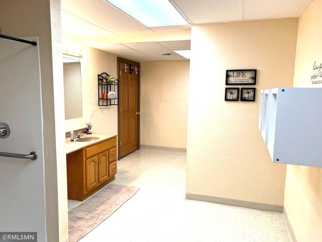 bathroom with a drop ceiling and vanity