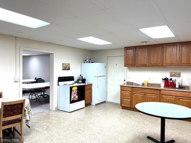 kitchen featuring a paneled ceiling and white appliances