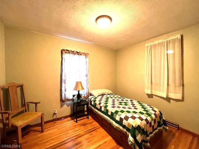 bedroom featuring hardwood / wood-style floors and a textured ceiling