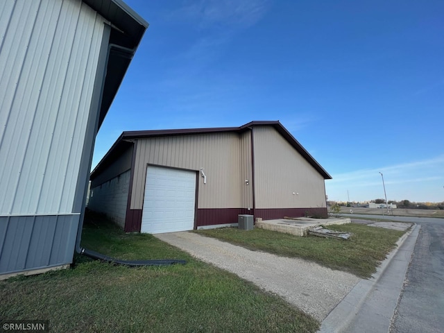 exterior space featuring a garage and a lawn