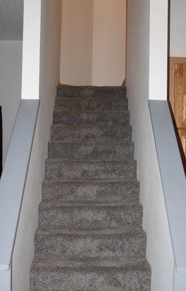 stairway with a textured ceiling