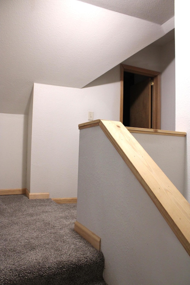 stairway with carpet and vaulted ceiling