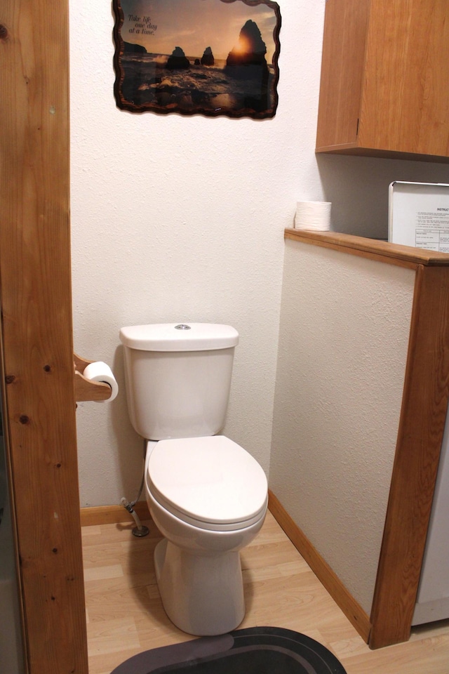 bathroom with toilet and wood-type flooring