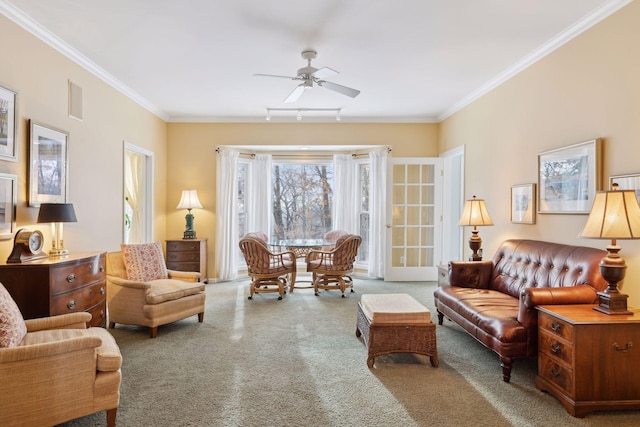 living room featuring carpet floors, ornamental molding, rail lighting, and ceiling fan