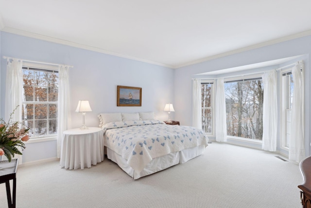 carpeted bedroom with ornamental molding and multiple windows