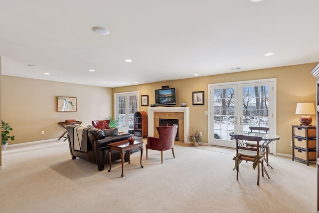 carpeted living room with a tile fireplace and french doors