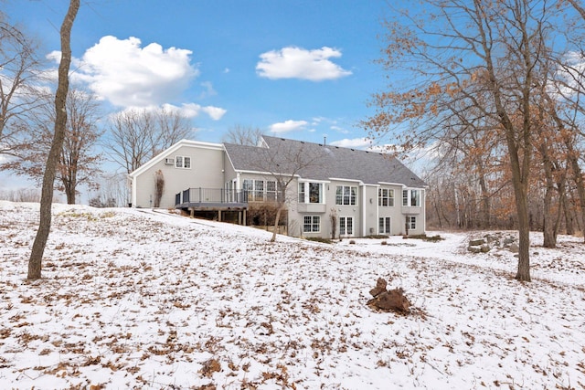 snow covered house featuring a wooden deck