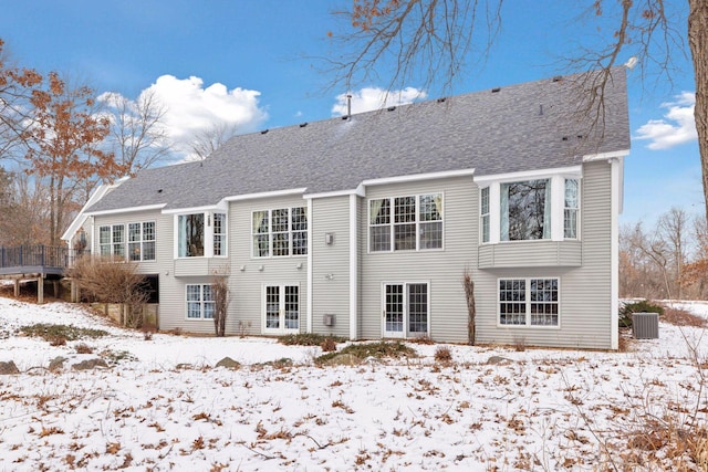 snow covered property with central AC unit